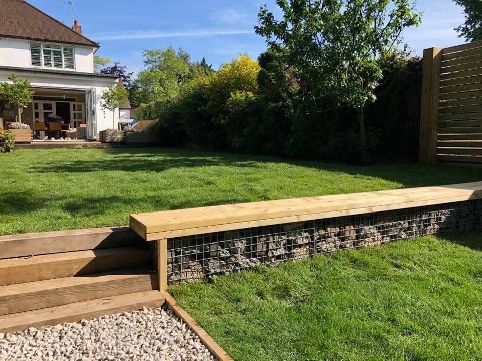 Garden transformation with turf, timber bench and gabion stonework